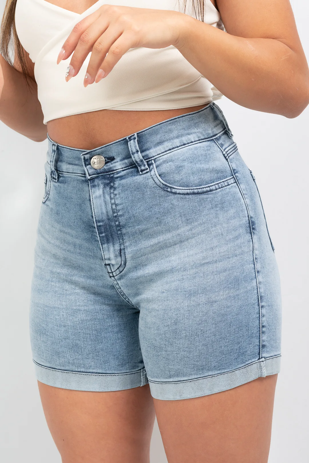 Detalle de lavado nevado y efecto bigotes en frente de short de jean