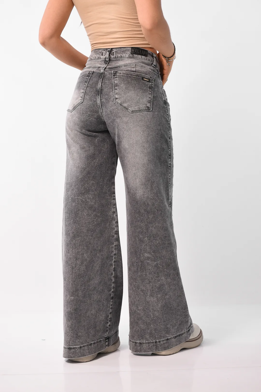 Silueta de modelo con jean wide leg gris tiro alto y detalles de tachas