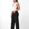 Pantalón maxi wide leg negro elastizado con tachas metálicas laterales, vista frontal completa marca Rumaju Jeans