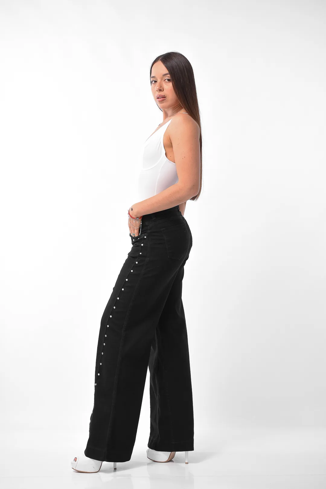 Detalle en primer plano de tachas metálicas en el lateral de jean negro wide leg