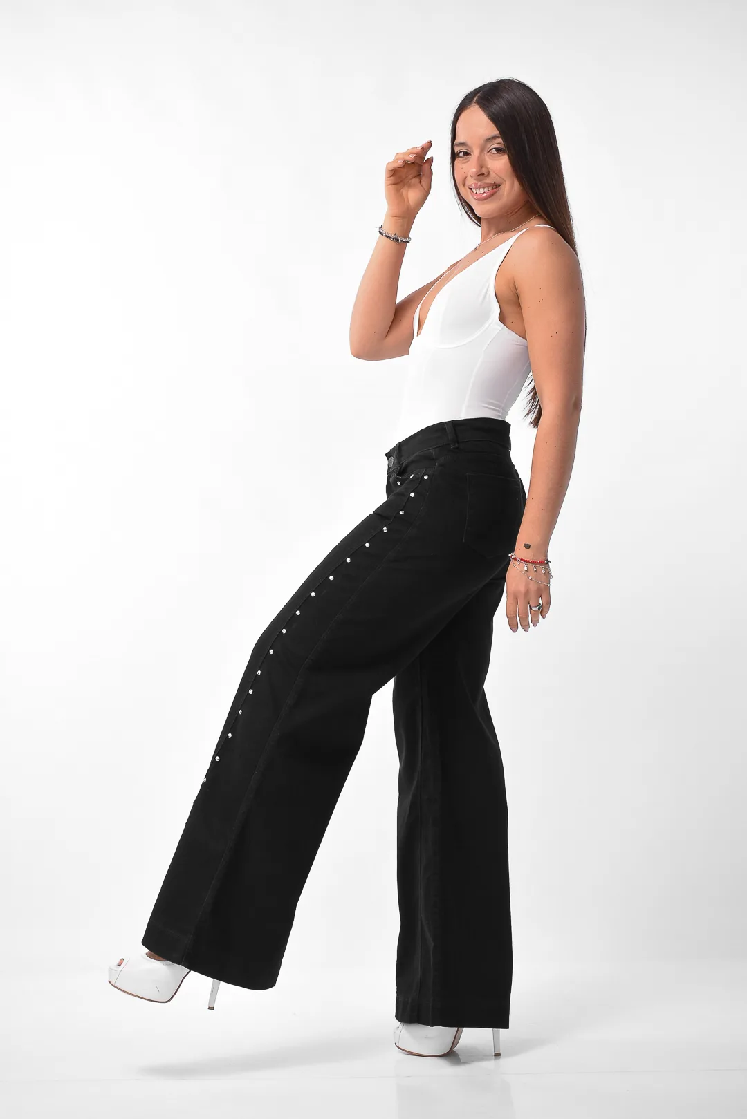 Detalle de cintura alta y calce trasero en pantalón maxi wide leg negro con tachas