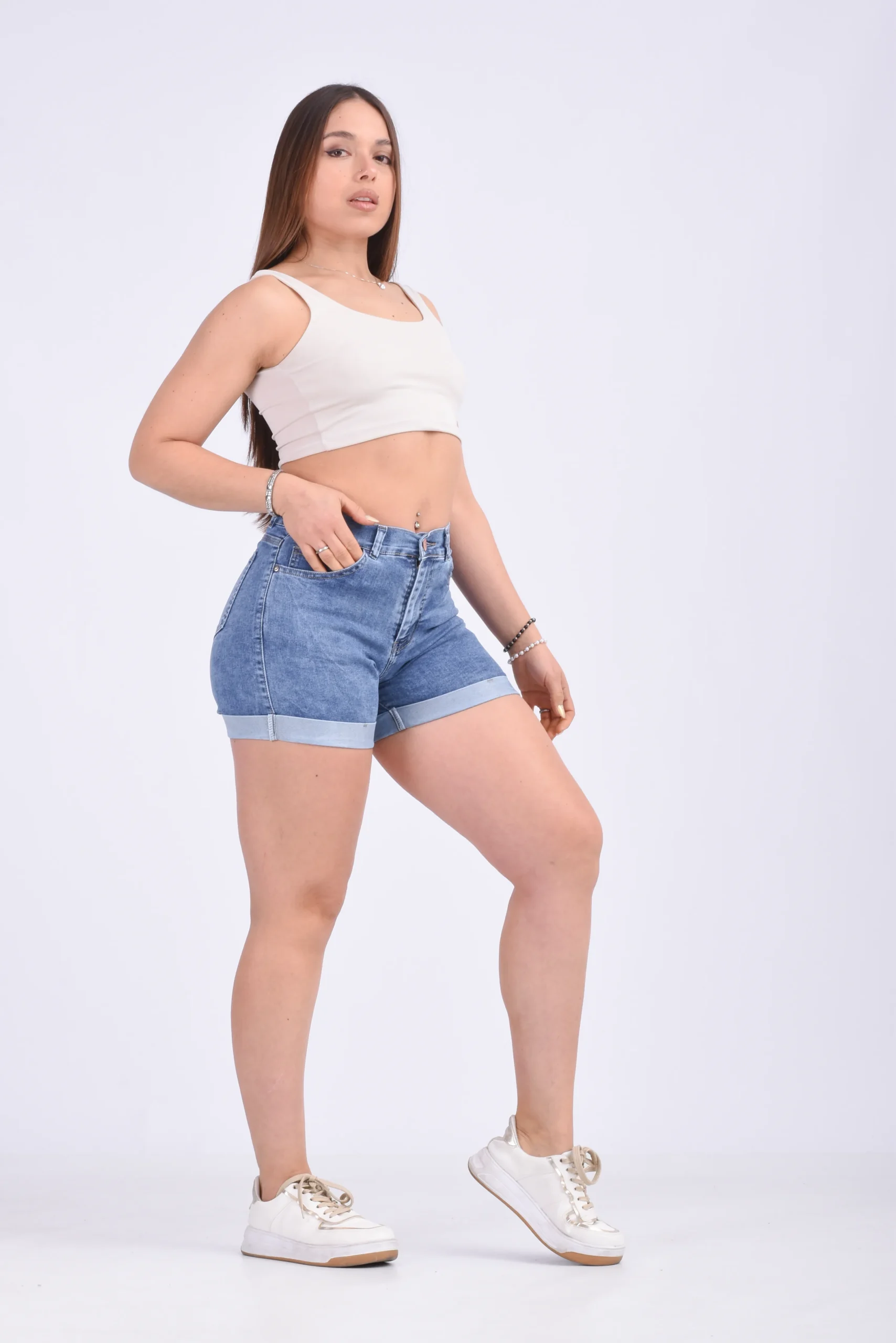 Vista lateral de short de jean azul elastizado con doblez confeccionado hacia afuera
