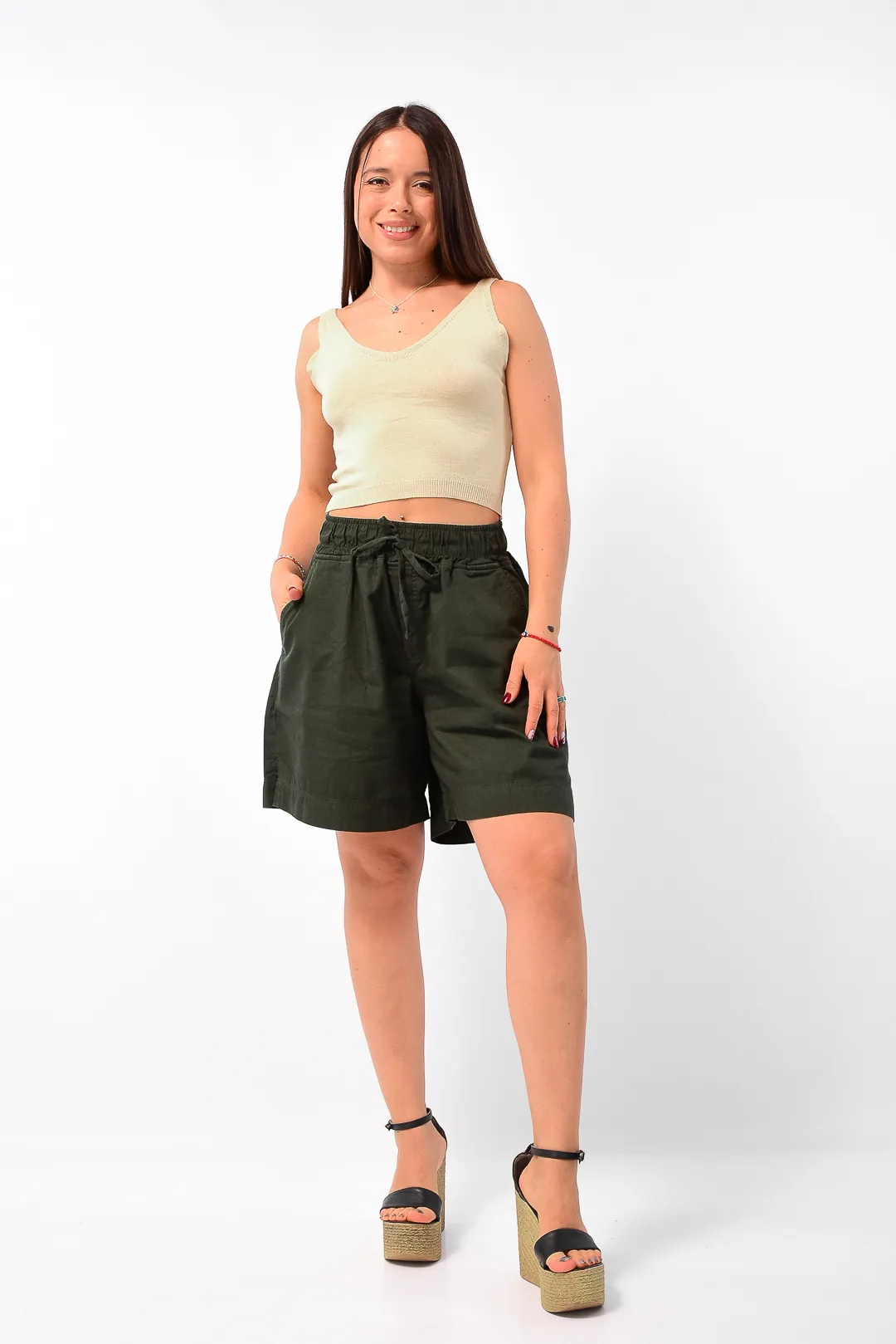 Plano tres cuartos de modelo vistiendo short de gabardina verde tiro alto Morgan